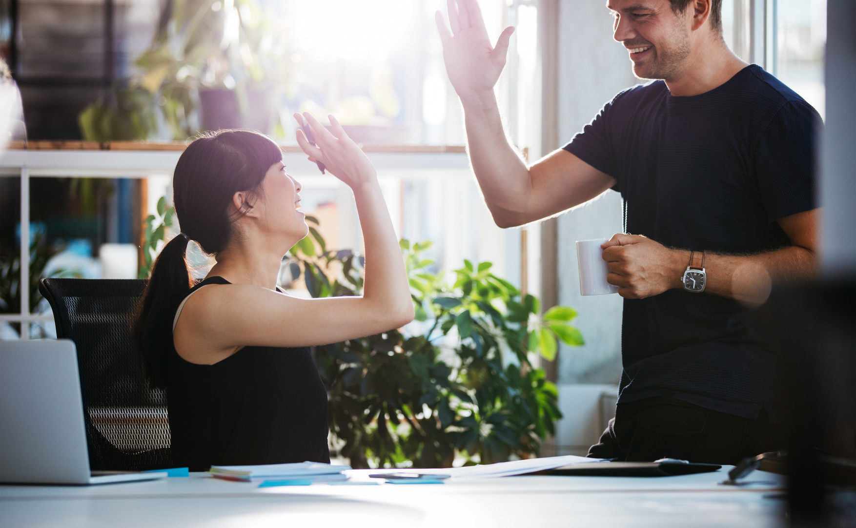 Successful business colleagues giving high five