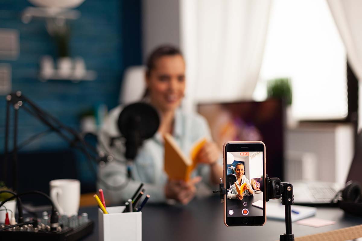 A woman recording a video on her smartphone, illustrating digital content creation in small business marketing strategies.