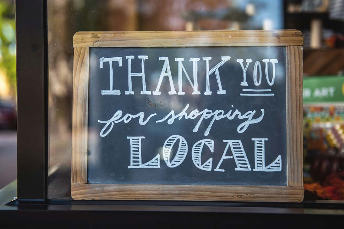 Shop local sign in storefront window, Pioneer Valley WordPress supporting local businesses