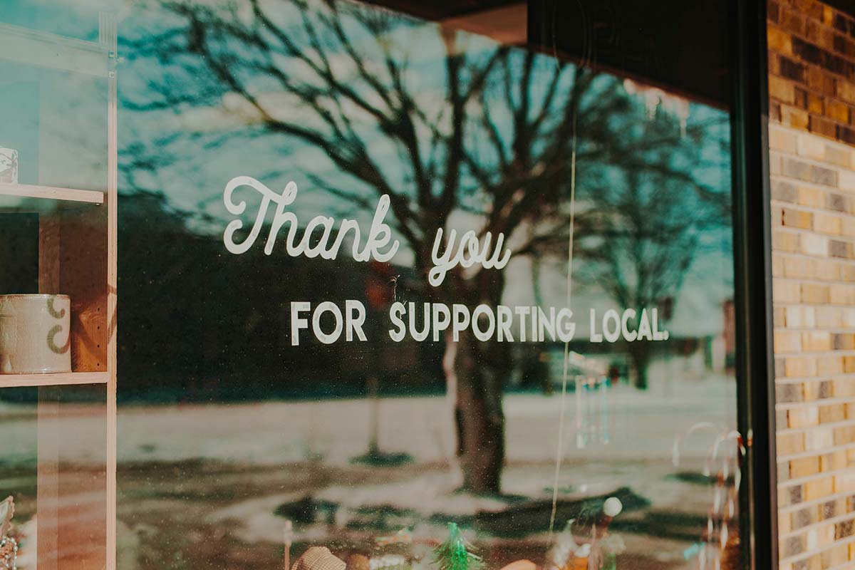 Storefront of a local business with a window sign saying thank you for supporting local, representing Springfield, MA SEO for local brands