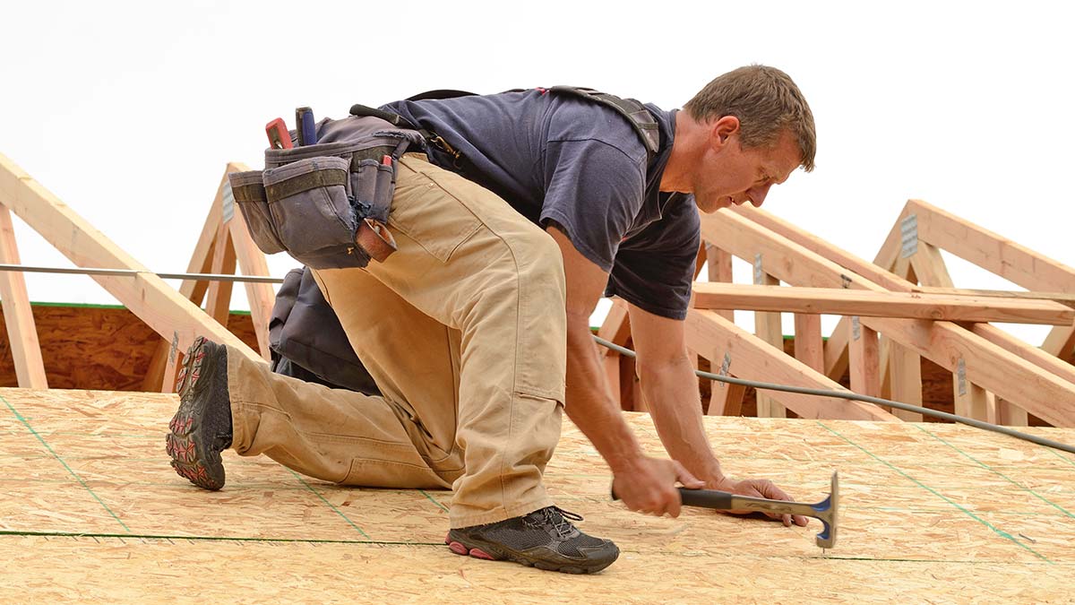 Roofing contractor building a new roof, highlighting the value of quality roofing marketing and website content