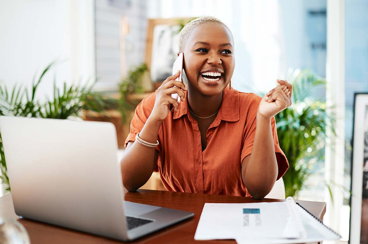 Customer service professional smiling while speaking with a customer on the phone