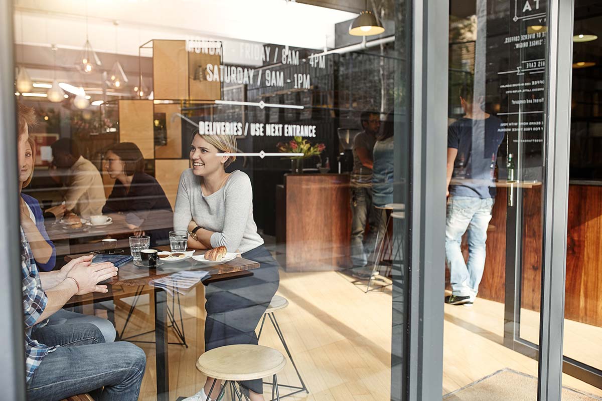 Customers and employees inside a neighborhood cafe, reflecting how company culture shapes the customer experience